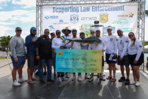 a group of dolphin-tournament winners holding check